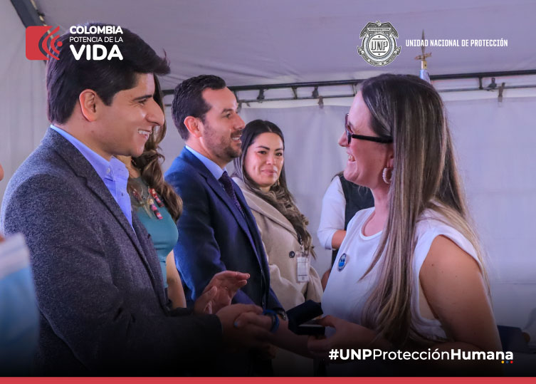 Directivo de la UNP entregando condecoracion a una mujer.